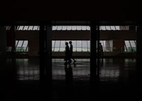 Home Silhouette of people walking through a modern hallway with large windows in Shanghai, China.